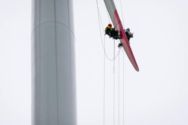 Técnico suspendido realizando trabajos sobre una pala de aerogenerador