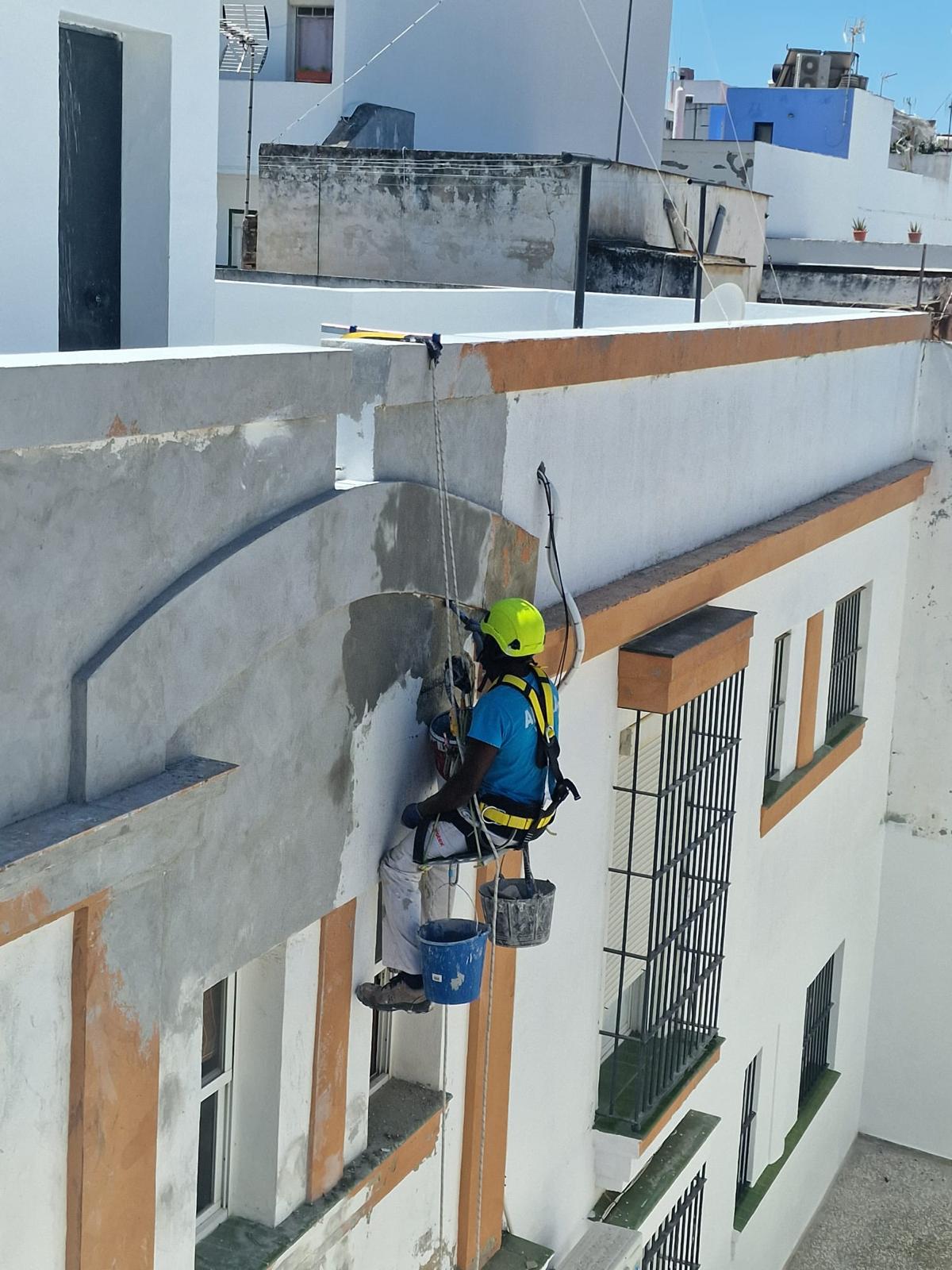 Técnico de ANARA Verticales reparando la cornisa de un edificio suspendido con cuerdas