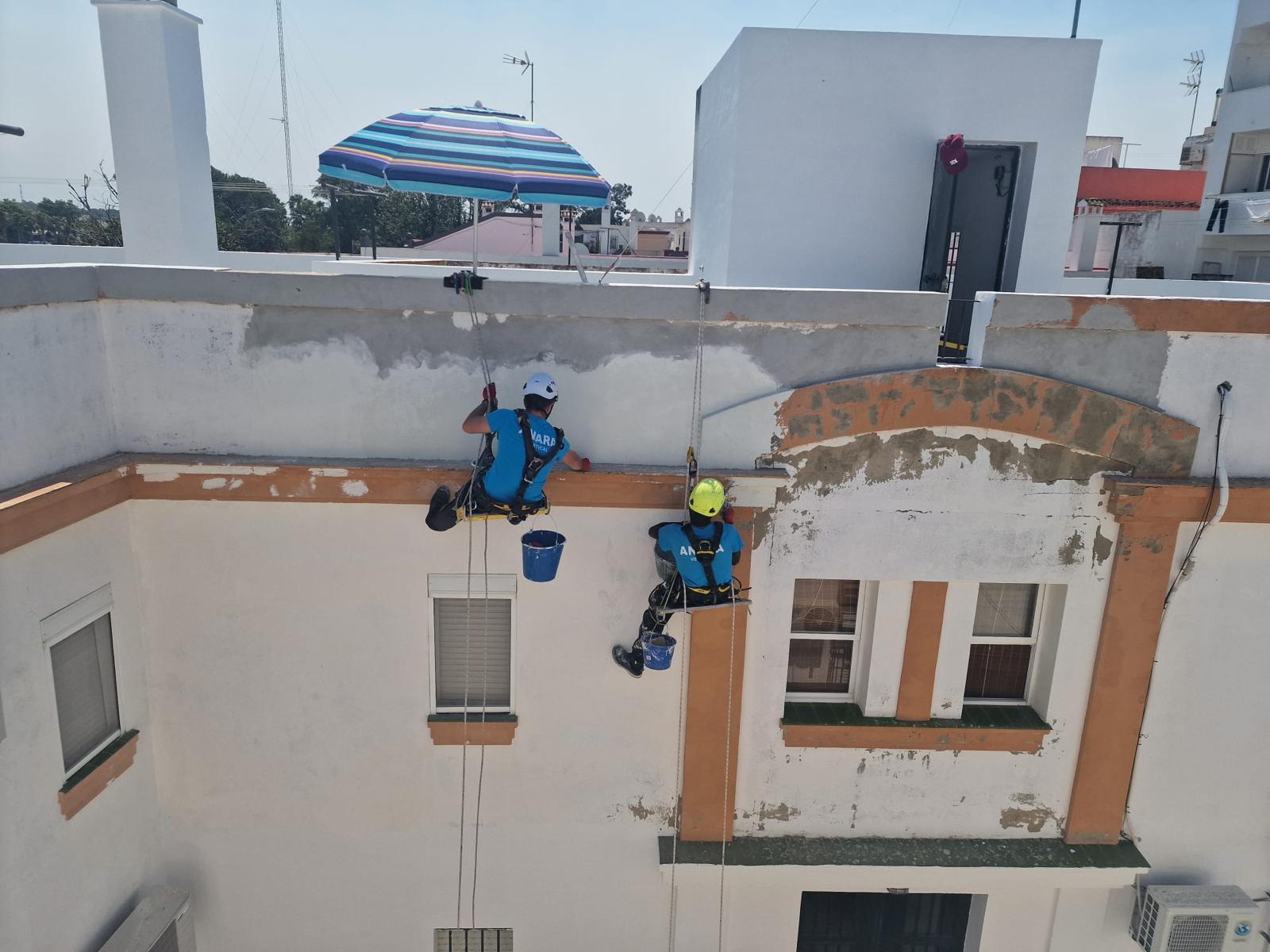 Técnicos de ANARA Verticales saneando la cornisa de un edificio de viviendas