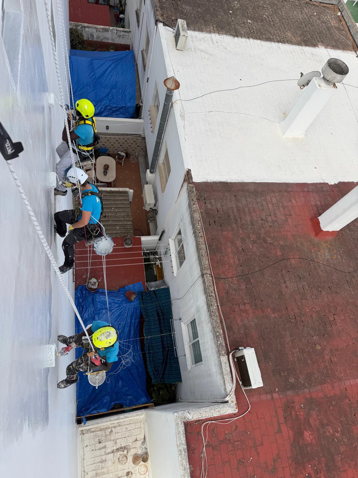 Equipo de trabajos verticales rehabilitando el patio interior de un edificio